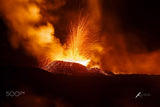 Macro de pahoehoe en mouvement, surface lisse et brillante, lumière incandescente sous une croûte fine