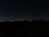 Vue panoramique nocturne de la coulée serpentant entre la forêt du Grand Brûlé et l'océan, lune diffuse au-dessus